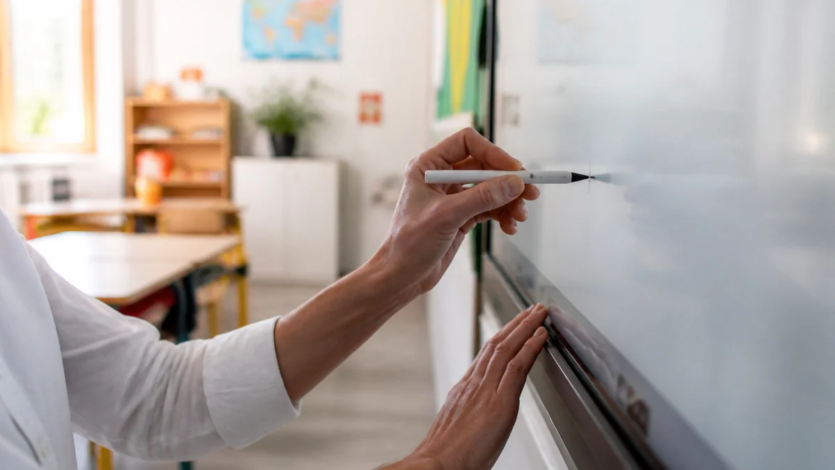 Enseignant qui prend en main son tableau blanc interactif au stylet pour le calibrer